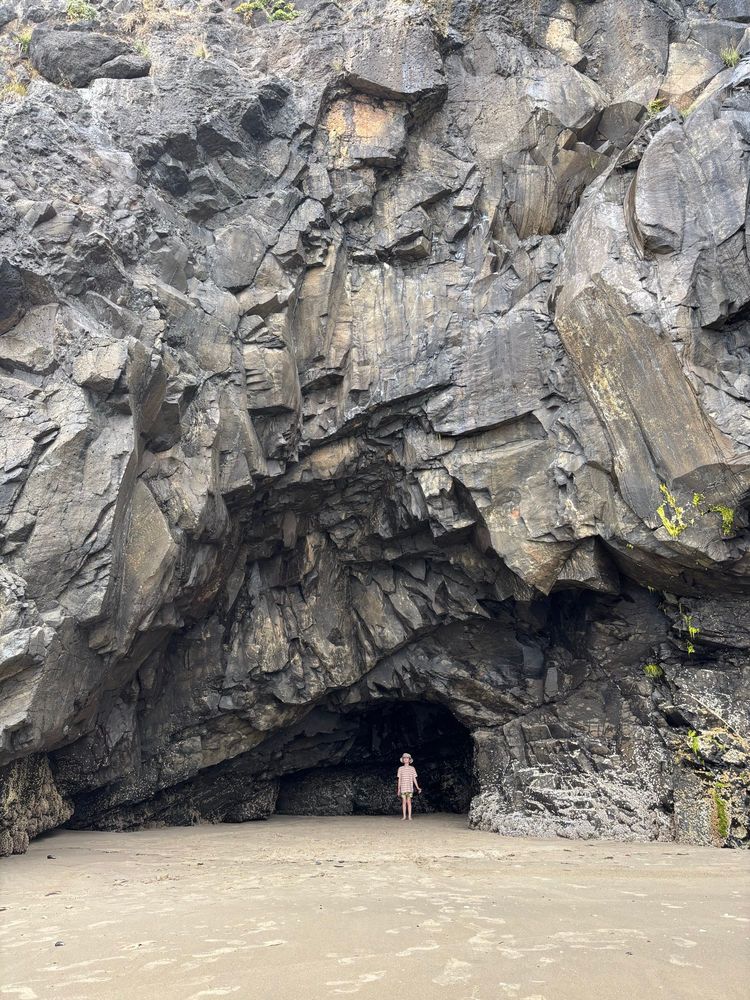 Strong Boy under a huge mass of rock in a sideways tear shaped tunnel. He looks like a splinter compared to the massive rocks overhead