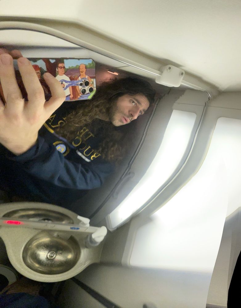 panaroma selfie of me in a small airplane bathroom with a warped prespective