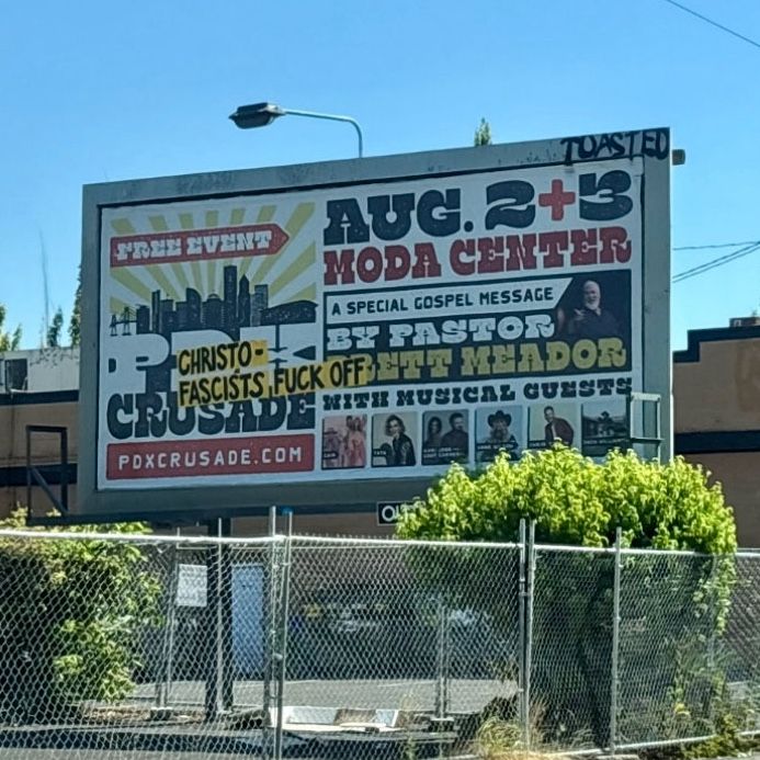 A photo of a billboard for an event called "PDX Crusade". The words "CHRISTOFASCISTS FUCK OFF" have been affixed to the billboard.