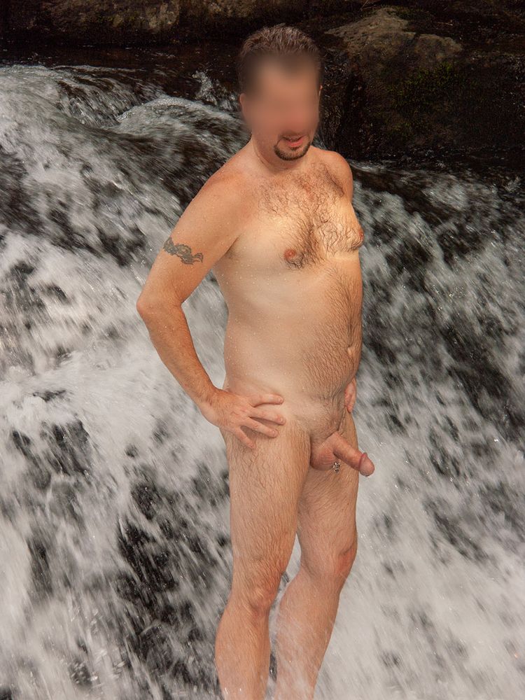 Me, naked, standing in cascading water. My cock is semi-hard.