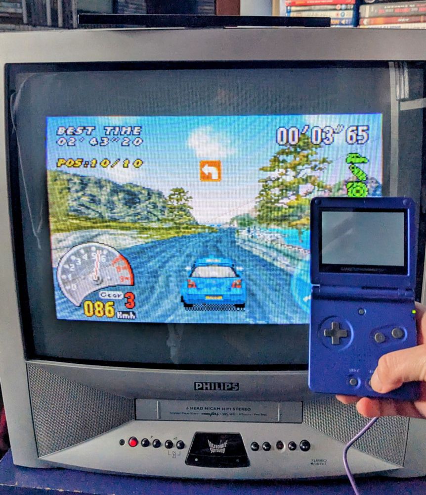 A Gameboy Advance SP is shown plugged while the CRT TV is showing V-Rally 3.