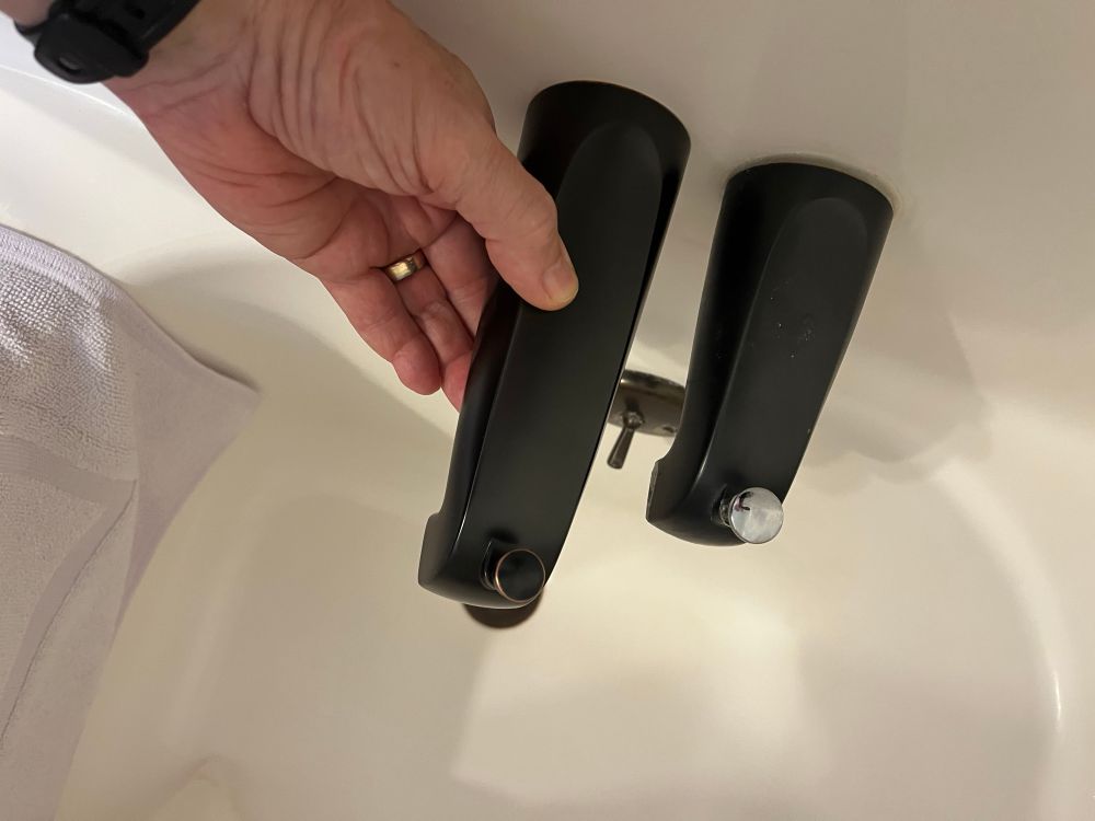 Two oil rubbed bronze tub spouts, side by side. The new one is 50% longer than the original. The old spout’s diverter stem is chrome, doesn’t match and obviously had been replaced by a friggin amateur