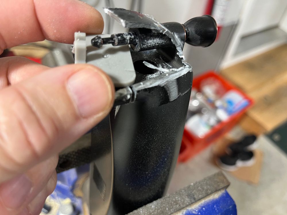 Tub spout end cut apart. Fingers grabbing the grey plastic diverter part from the dissected metal spout