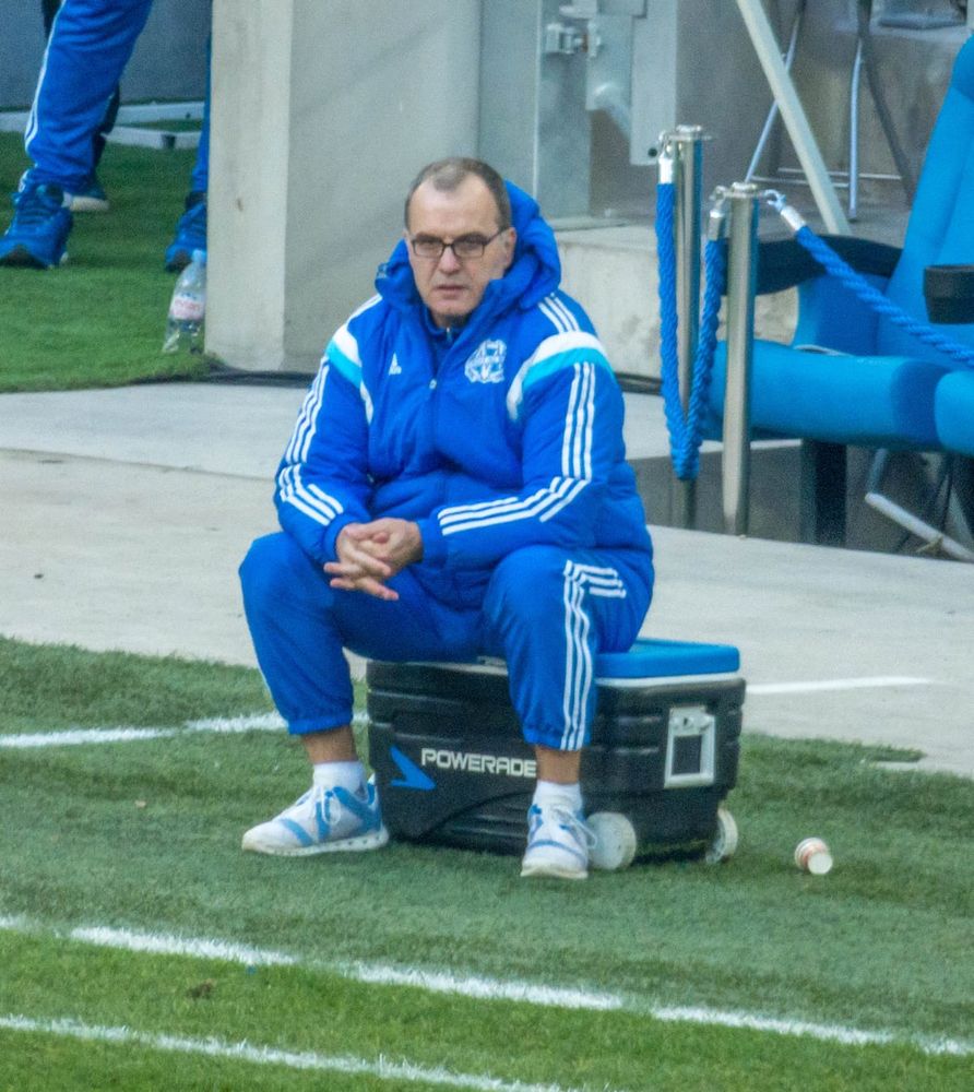 Marcelo Bielsa sitting with his hands crossed on a cooler.