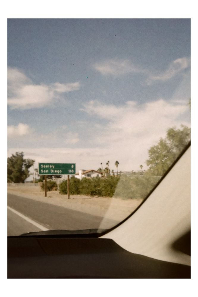 Interstate sign viewed out a car window, 118 miles to San Diego.