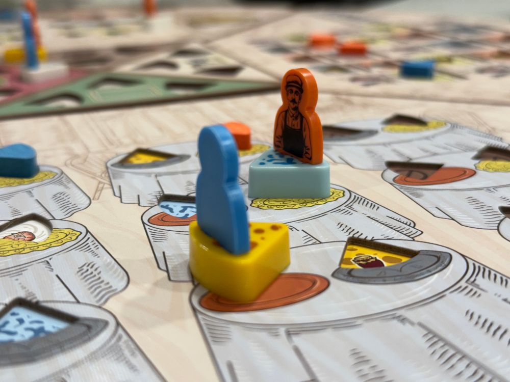 Two worker pieces from the board game fromGe, sitting in the bistro quadrant looking at each other. 