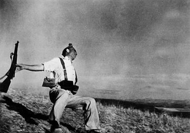 black and white photo of a man falling over while holding a gun
