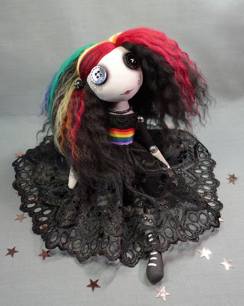 a button eyed art doll in black lace dress with rainbow coloured hair and belt