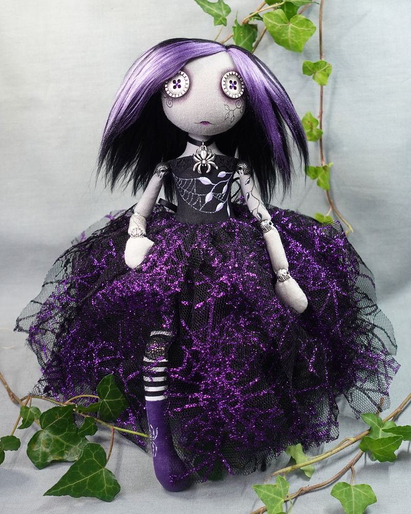 gothic style button eyed doll in purple and black dress with spider and web detail