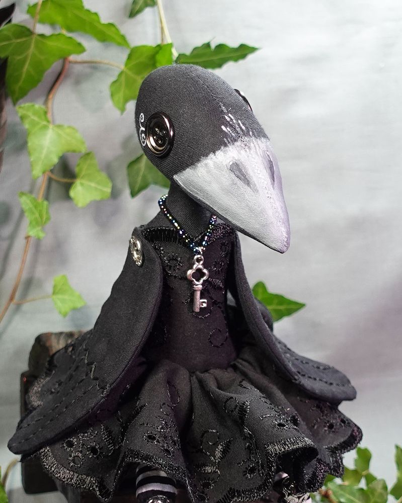 a button eyed crow doll with hand painted beak and hand stitched wings