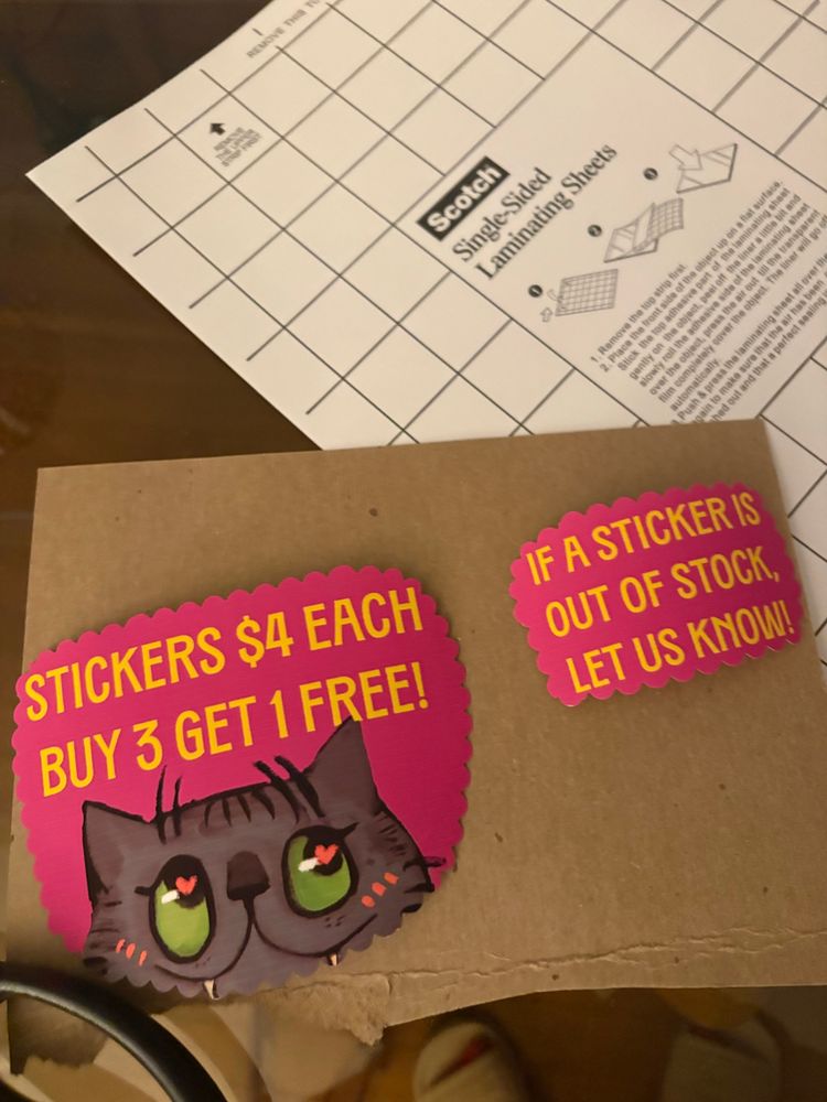 sticker paper for sticker signage featuring korjik, with a card board behind the cut out signs 