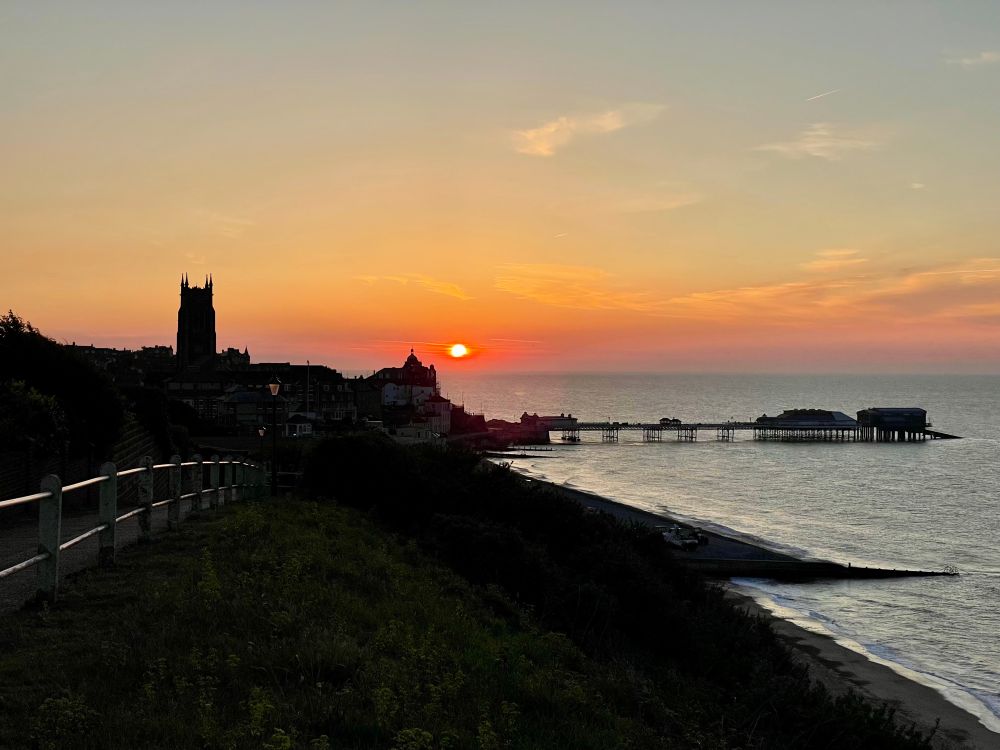Sunset with Cromer church and pier silhouetted.
