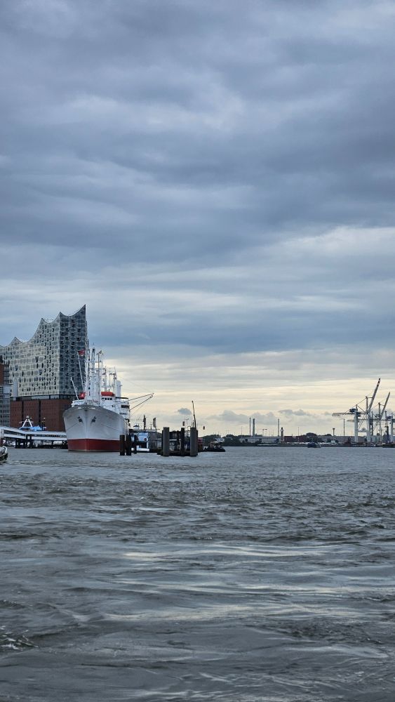 Die Elbe mit stahlgrauem Wasser und dunklem Himmel, Cap San Diego und der Elphi. 