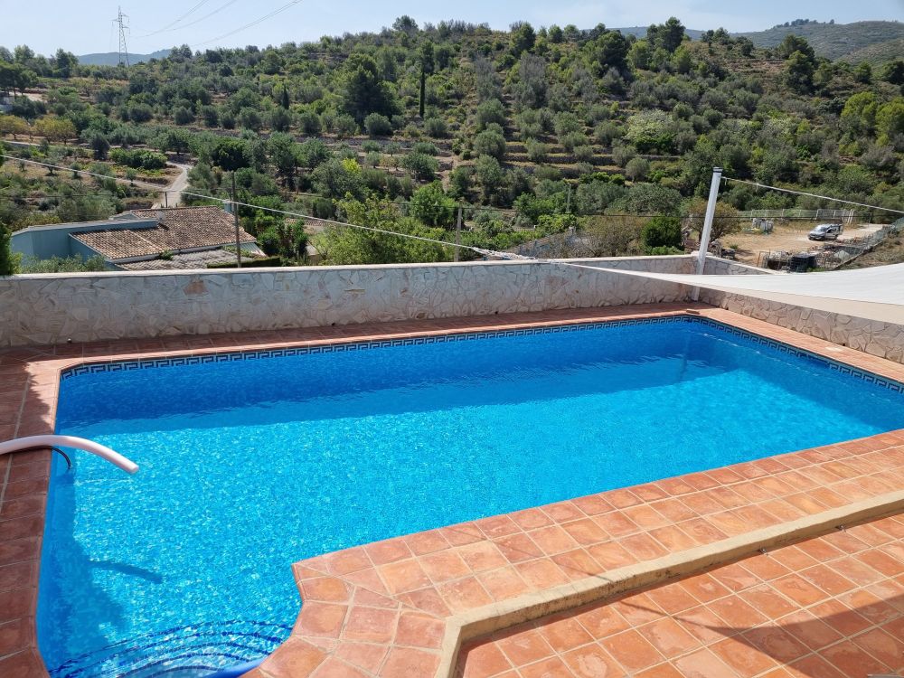 Swimmungpool in Blau, im Hintergrund Olivenhaine