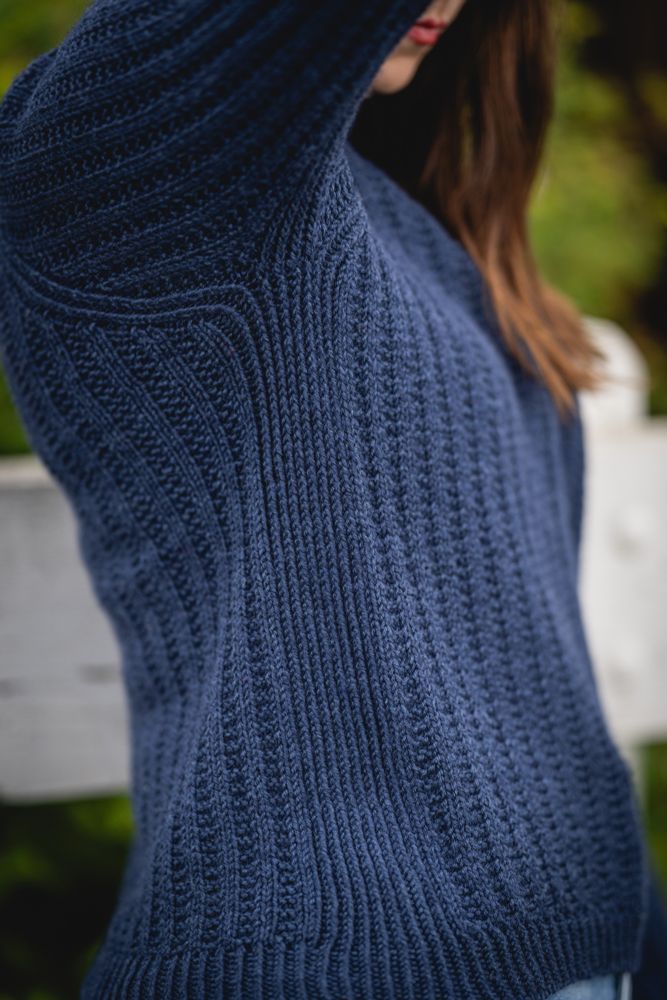 Side details of a hand knit long sleeve raglan sweater with broken rib