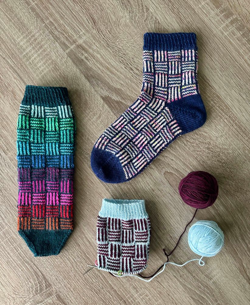 Hand-knit colorwork socks on a wood grain desk