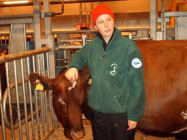 I'm standing in front of a cow and scratching her head (she was a big fan of scritches ❤️). Year is 2012 and the picture was taken at the University's research farm.