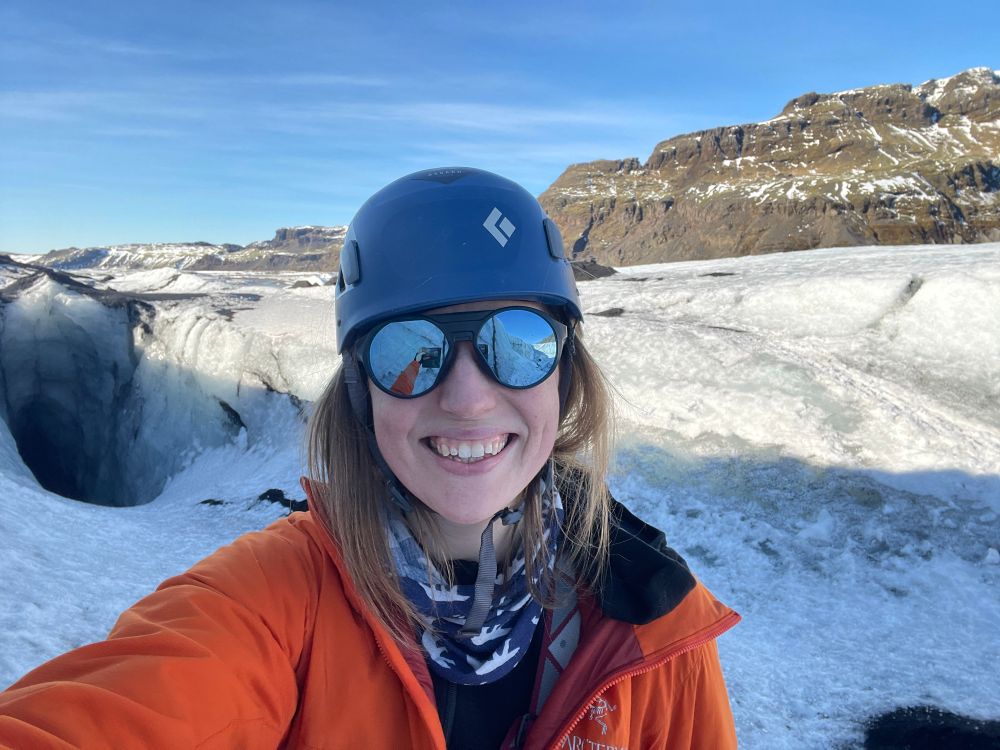 Penny in Iceland last week. She is taking a selfie on Sólheimajökull, wearing a helmet, sunglasses, and gear for being on a glacier and learning some rescue training. It is very sunny and warm, so smiles all round!