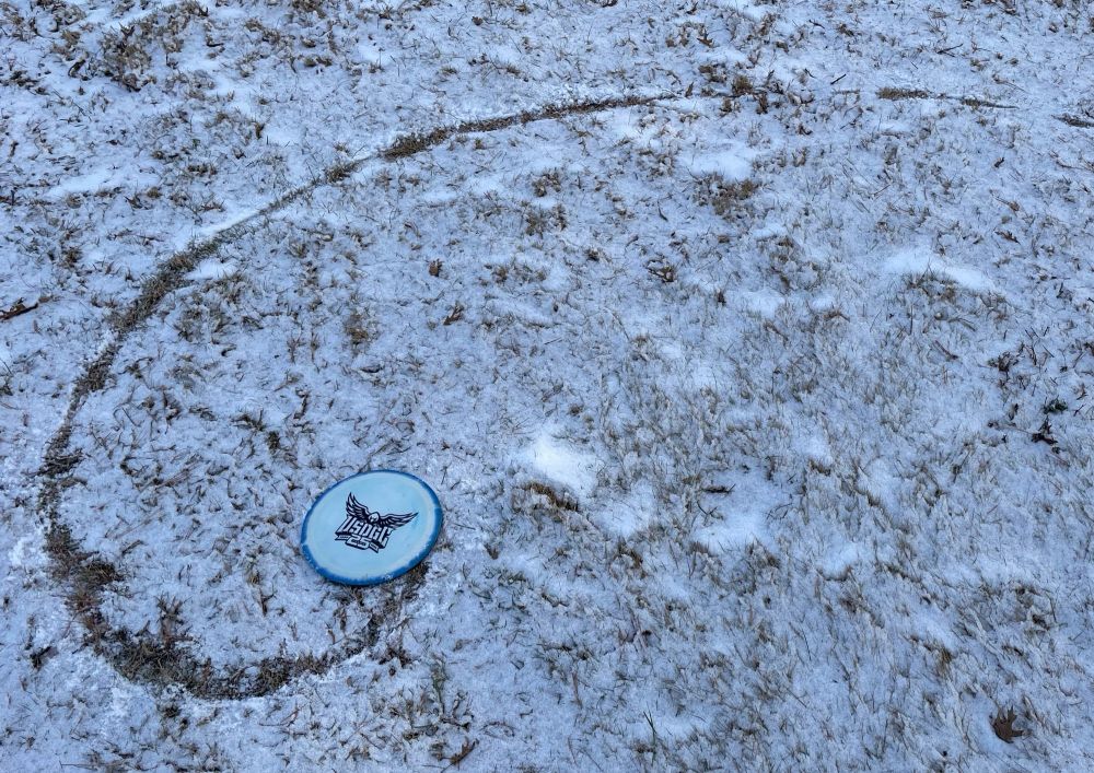 Disc in the snow with a spiral trail.