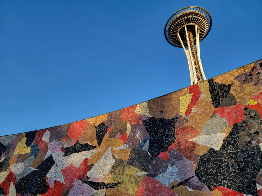 Paul Horiuchi's colorful, collage style Mural Amphitheater, with the bright white Space Needle against a cloudless blue sky in the background