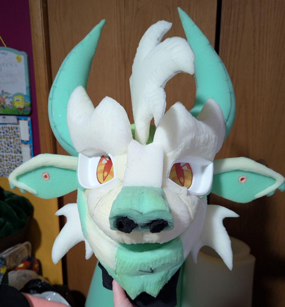 A finished fursuit foam head base of a hodag. A front view.
