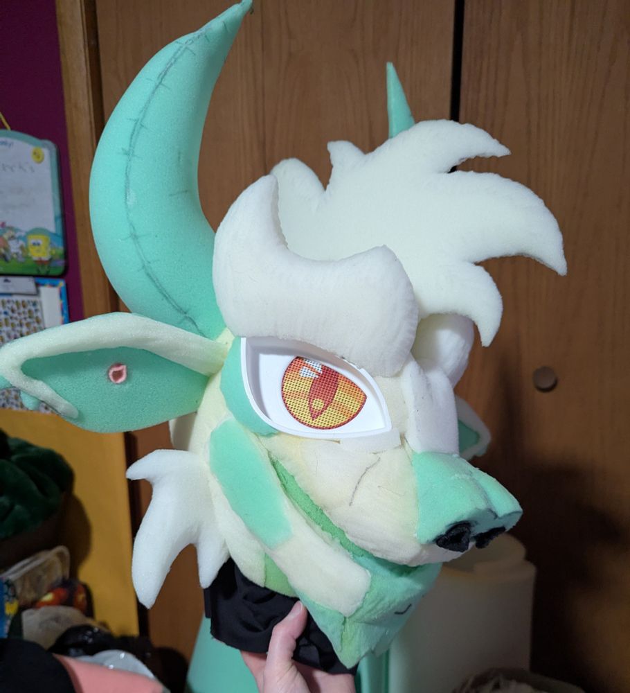 A finished fursuit foam head base of a hodag. A 3/4 view.