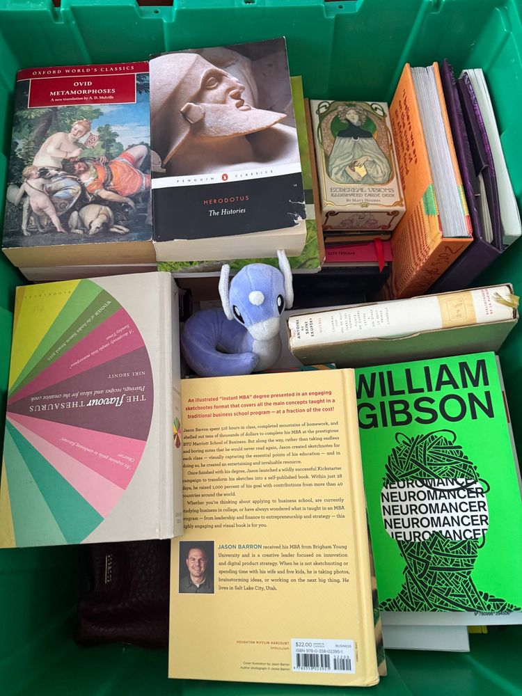 A box full of books with one little dratini in the middle of them 