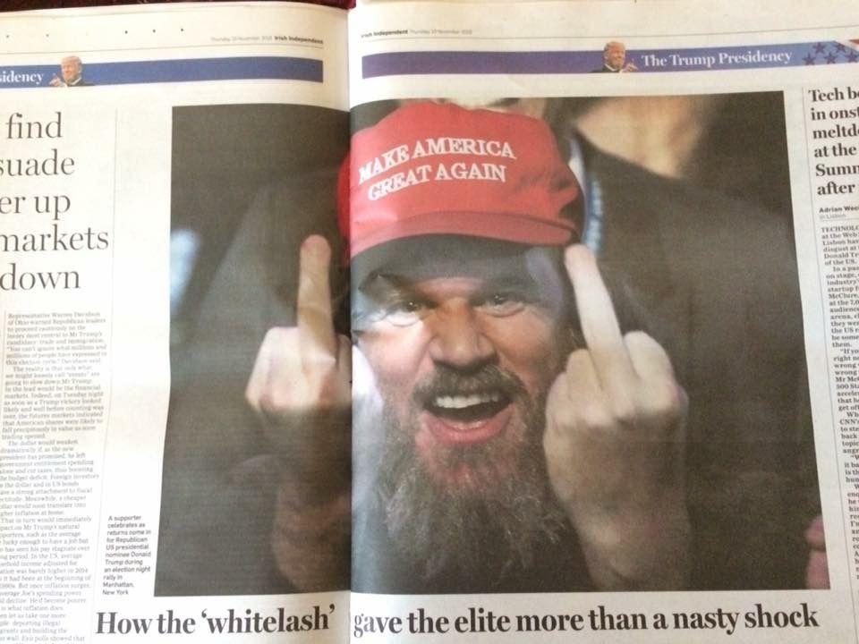 Irish independent center page the day after the 2016 US election showing a “real winner” of a hayseed in a red hat flipping double birds at the photojournalist.