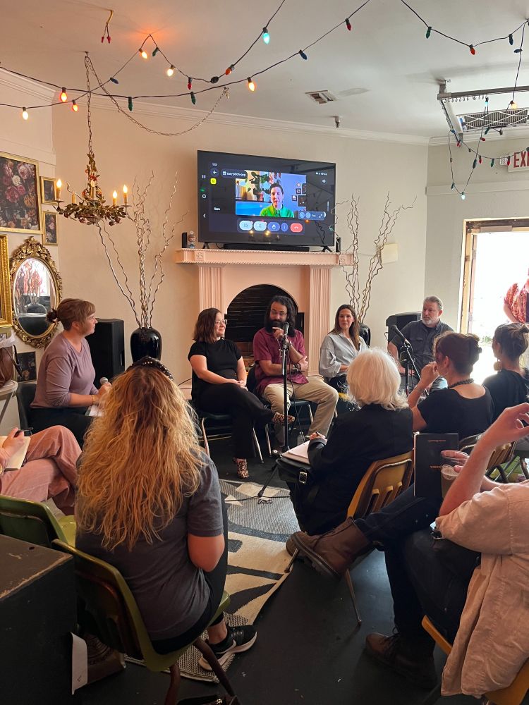 Another front facing shot, with the panel and moderator; with the backs of the guests' heads. 