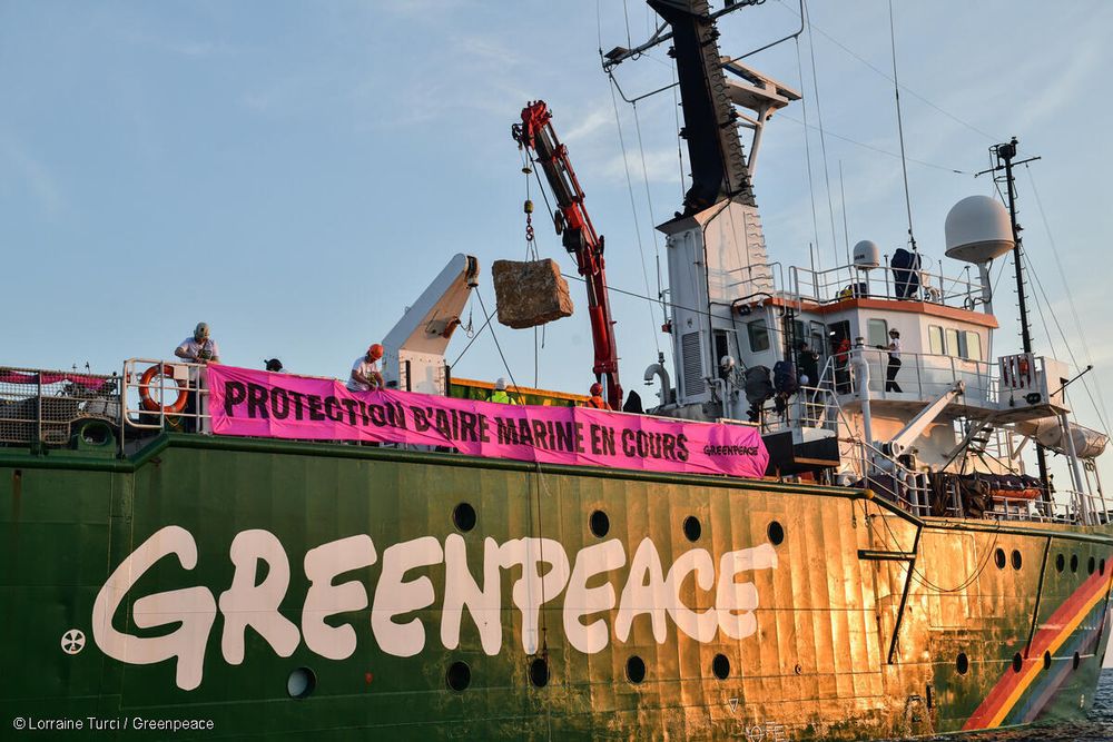 Bateau Greenpeace avec banner indiquant "Protection d'aire marine en cours"