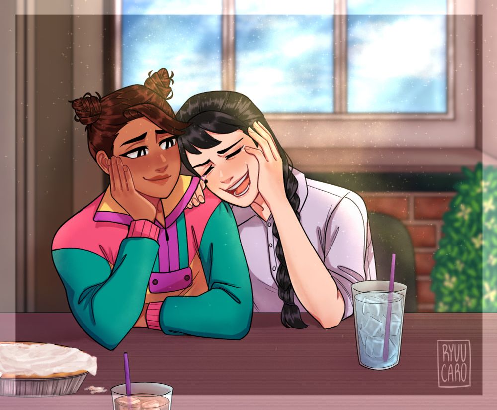 Akarsha sits beside Noelle, looking lovingly at her and leaning her face on her hand as Noelle laughs so hard she's leaning onto Akarsha. They sit at a restaurant, drinks in front of them and a pie off to the side of the table. 