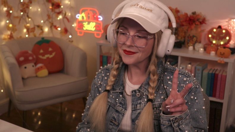 Violet in her stream room wearing a jean jacket 