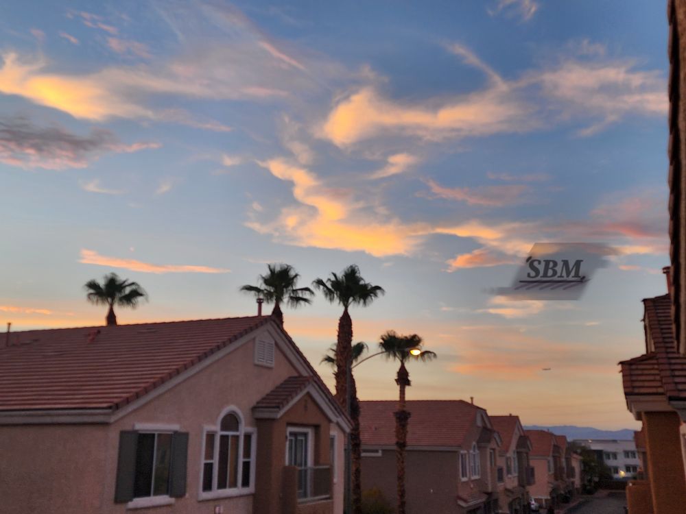 Wispy and trippy golden cirrostratus clouds over a pastel yellow and blue sunrise