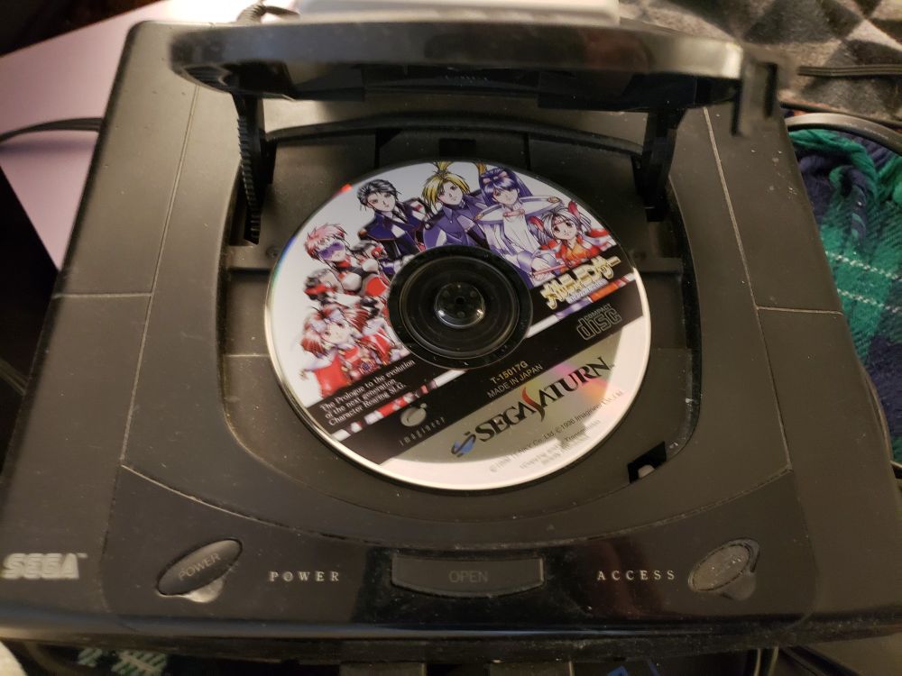The lid of the Sega Saturn open to reveal a copy of Melty Lancer (メルティランサー) still inside.