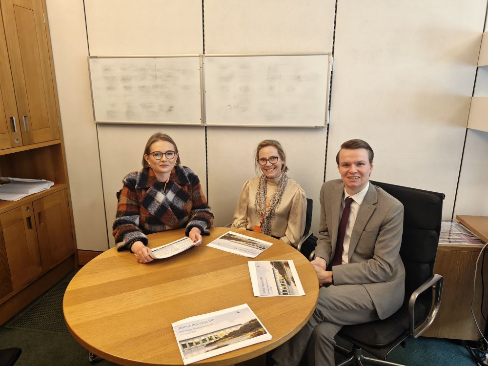 Josh sitting at a table in his office with two representatives of GWR