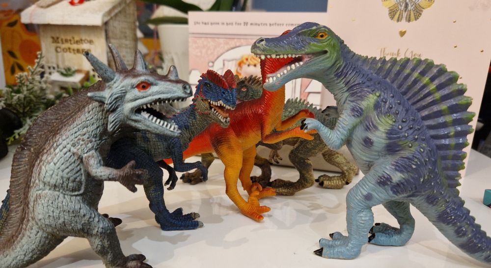 Toy dinosaurs and monsters on a table.
