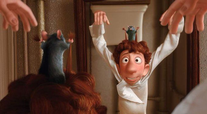 A still from the animation "Ratatouille." Remy the rat is pulling on the hair of a chef named Alfredo Linguini and controlling his arms.