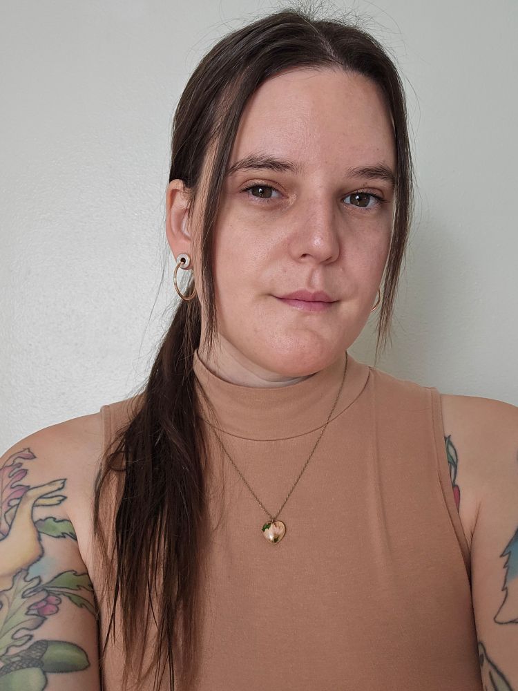 A pretty lady with tattoos and crazy long bangs