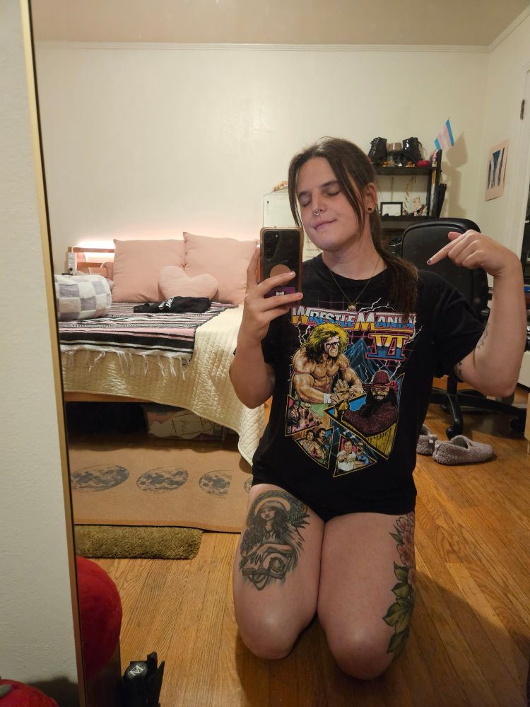 jamie is kneeling for a mirror selfie wearing an oversized wrestlemania shirt and no pants lol