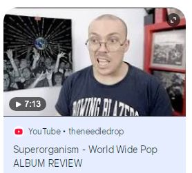 A thumbnail from Anthony Fantano's review of Superorganism's "World Wide Pop" album -- his mouth is open and he looks annoyed or something