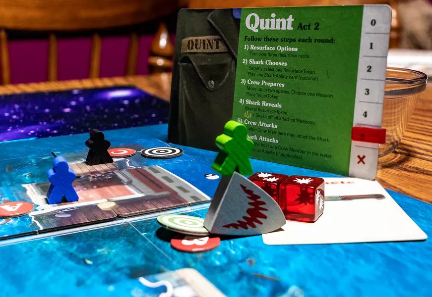 A photo from BGG of the second and final act of the boardgame JAWS. Quint has just killed Jaws with a machete after a fantastic roll