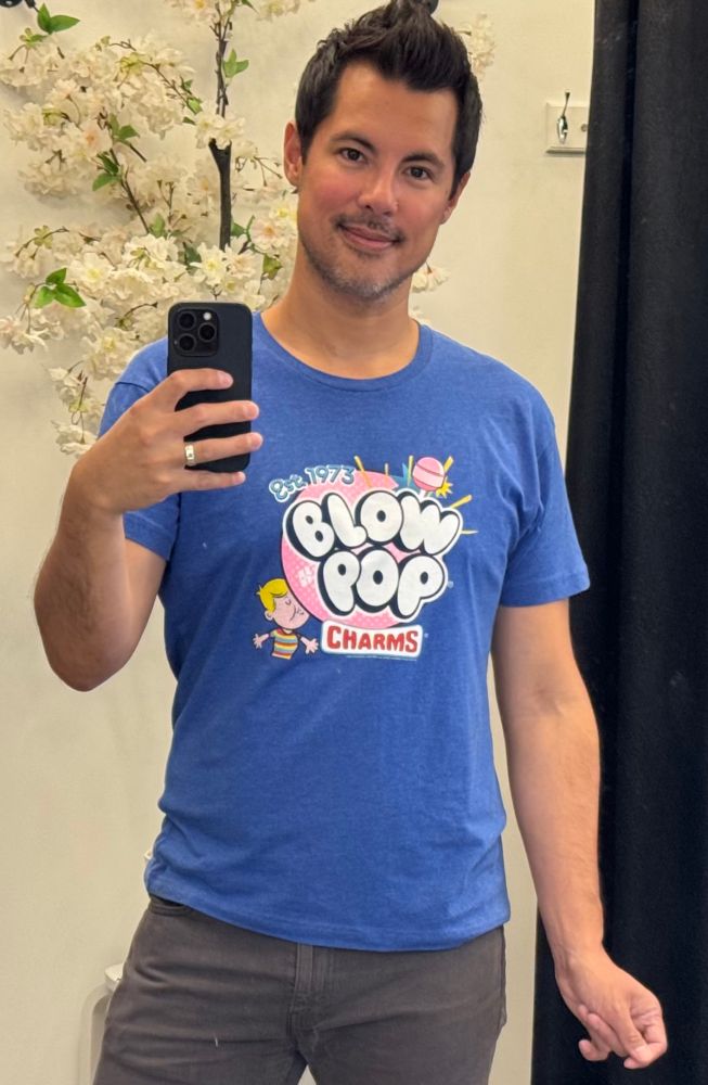 A mirror selfie of a middle-aged man standing in an exaggerated effeminate way.