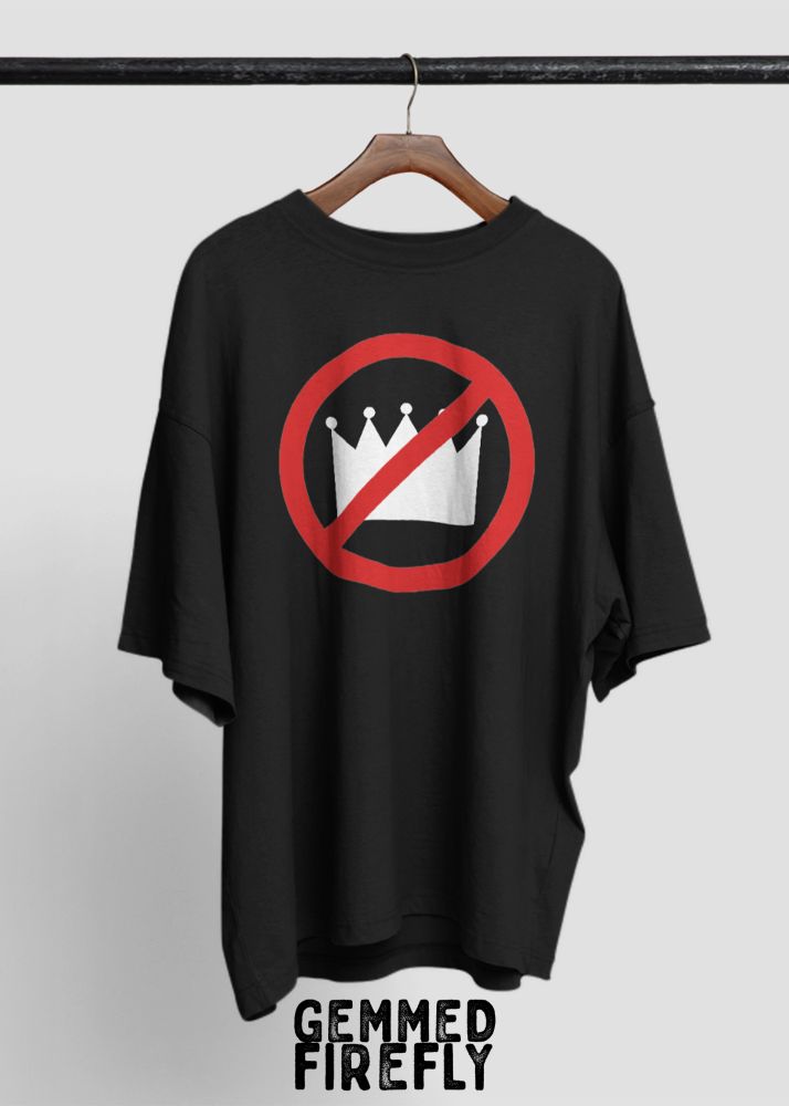 A black oversized T-shirt hangs on a wooden hanger against a plain backdrop. On the back of the shirt is a bold white crown symbol crossed out with a red prohibition circle and slash. Below the shirt, the brand name "Gemmed Firefly" appears in a bold, distressed font.