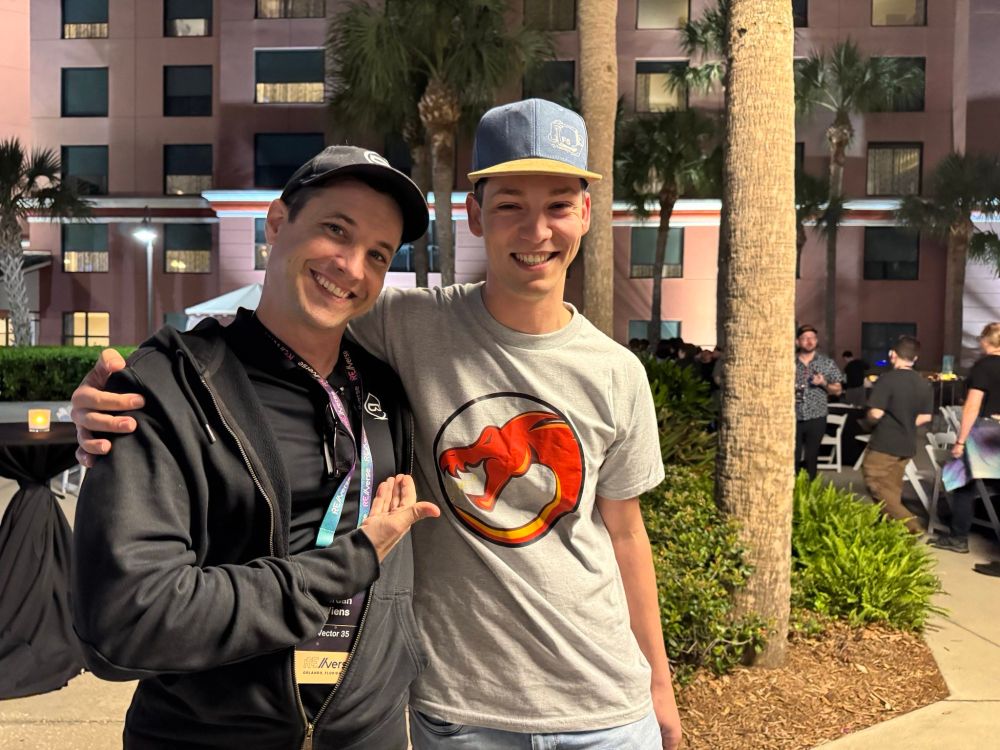 Jordan is wearing a Binary Ninja tshirt, hoodie, and cap, whereas Im wearing a Ghidra tshirt and a Hex Rays cap