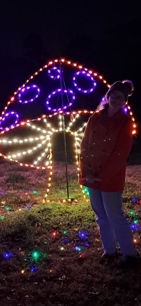 Me (Amanda) standing in front of a multicolored, Christmas light mushroom 