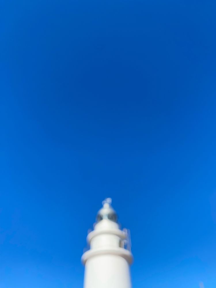 verschwommene Leuchtturmspitze auf blauem Himmel