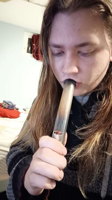 moose smoking weed from a small bong, looking down, please ignore the gamecube on my pillow