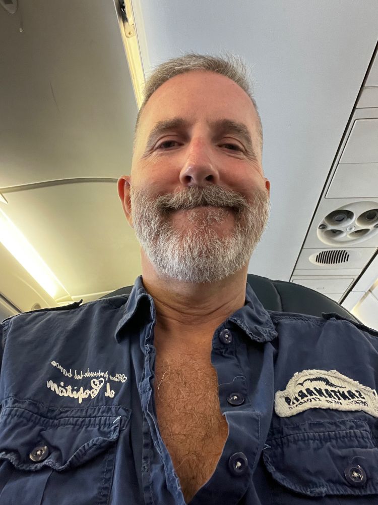 A dopey guy taking a selfie on a plane, novel. 