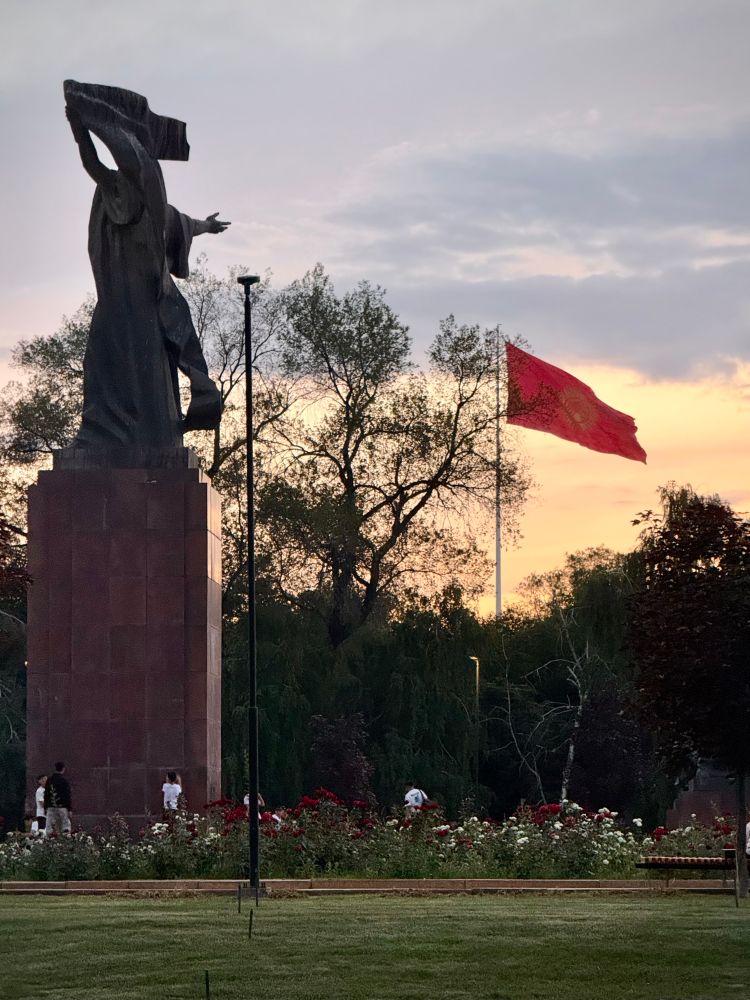 Image of Bishkek, with Kyrgyz Republic flag high in the sky at sunset