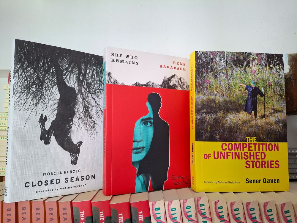 Image of finished copies of Closed Season, She Who Remains, and The Competition of Unfinished Stories 